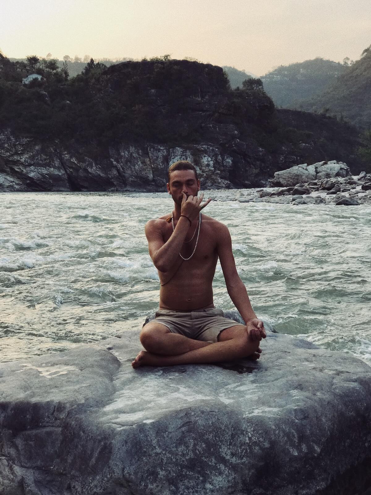 Dylan Smith doing Pranayam (movement of Prana) while sitting in a rock on a river