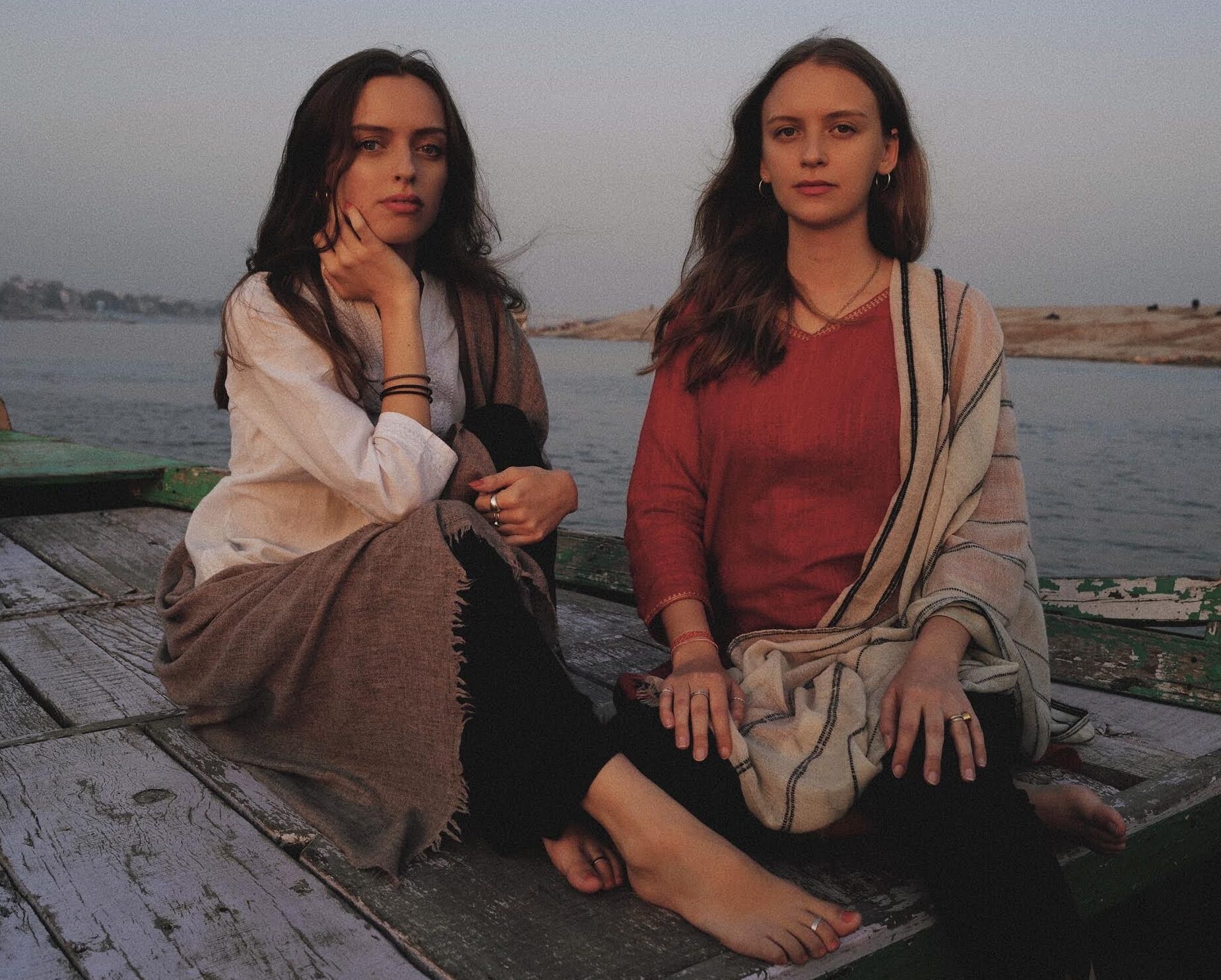 Kamala and Jahnavi from Samadhi Collective sitting next to the Ganges river