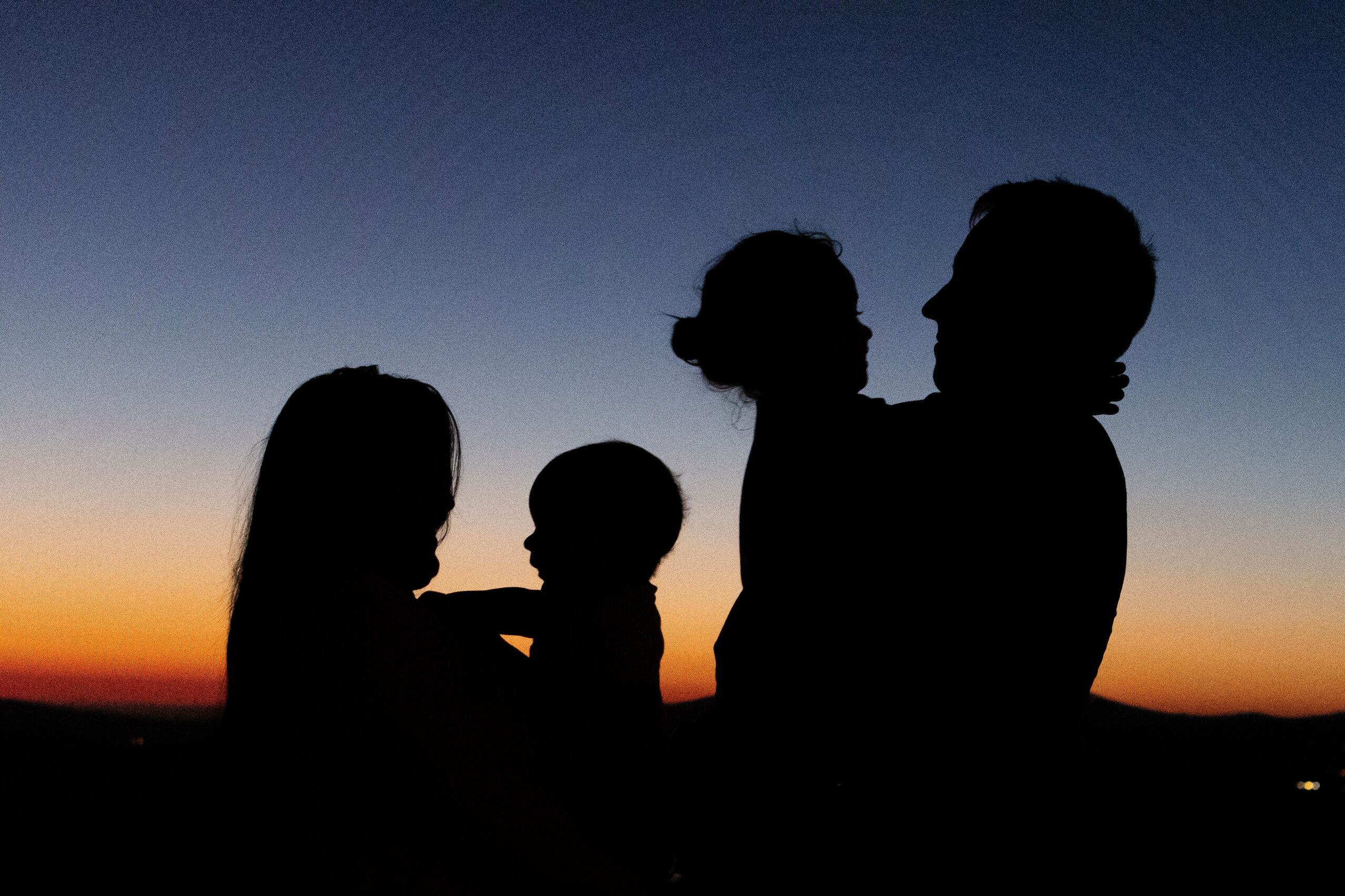 Silhouettes of parents and two children in sunset
